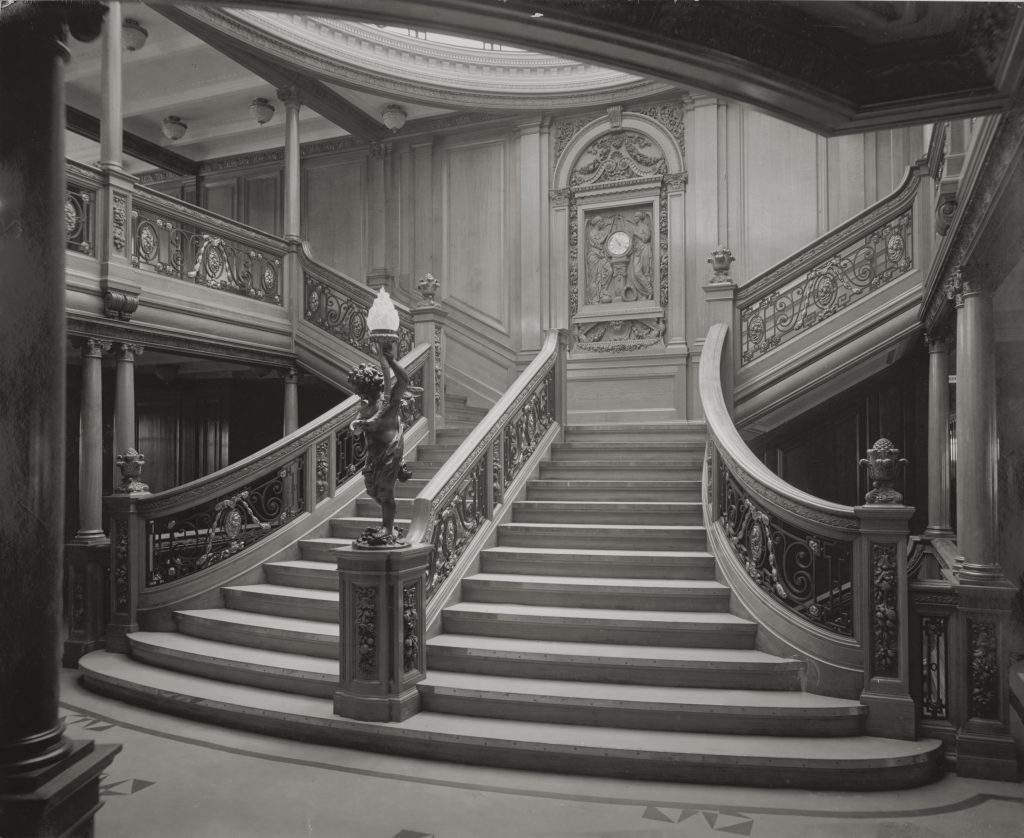 Questa immagine ha l'attributo alt vuoto; il nome del file è Grand_Staircase_aboard_the_RMS_Olympic_William_H._Rau_1911-1-1024x838.jpg